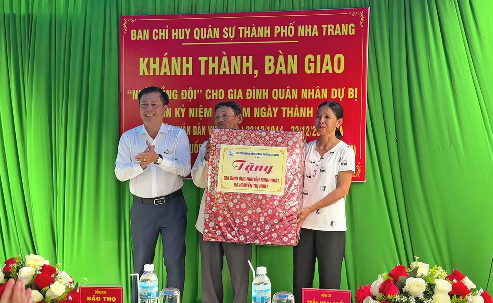 Ông Trần Minh Chiến tặng quà cho gia đình ông Nhật tại buổi lễ bàn giao nhà mới. 