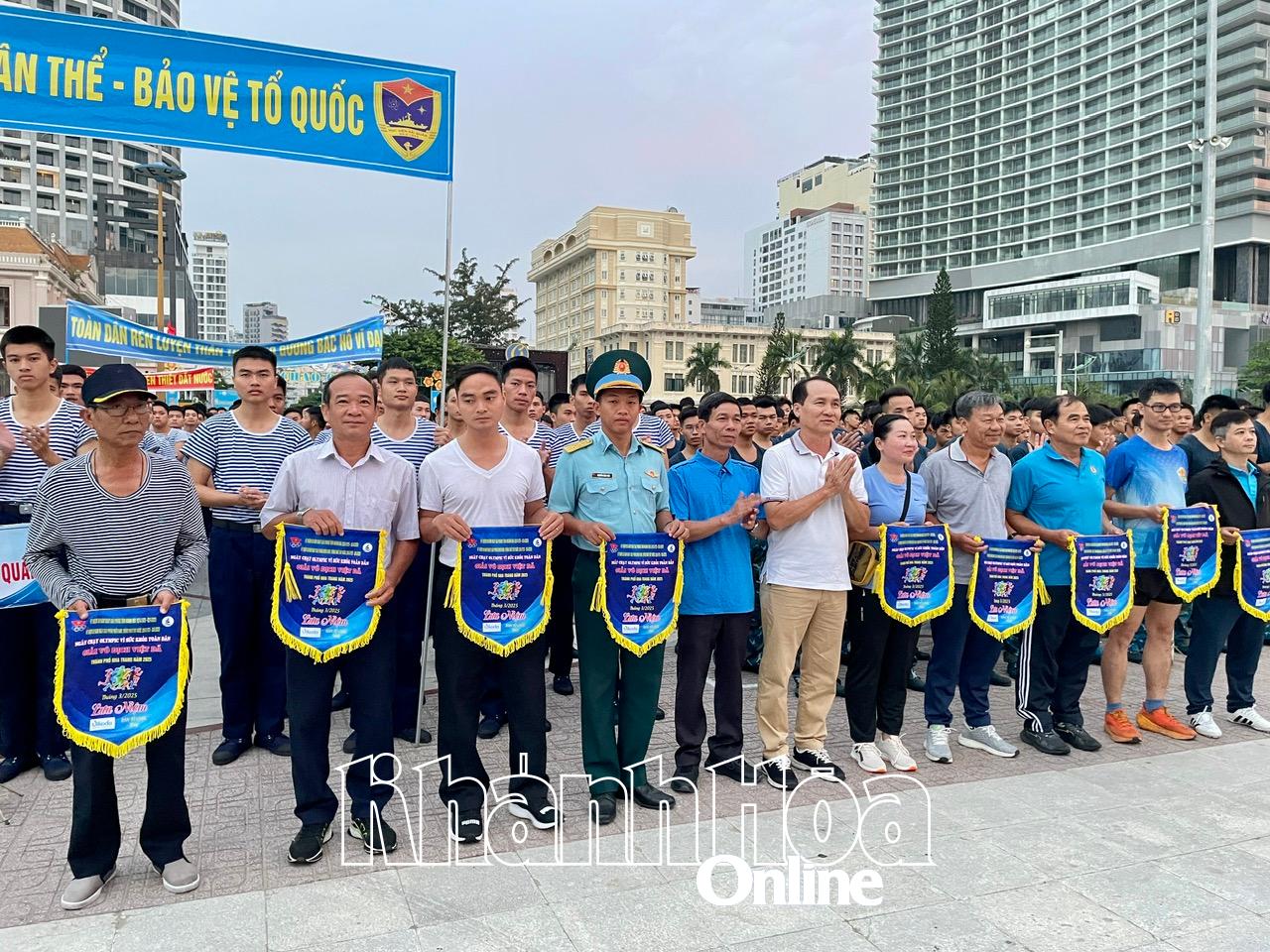 Ban tổ chức tặng cờ lưu niệm cho đại diện các đơn vị tham gia chạy đồng hành Ngày chạy Olympic.